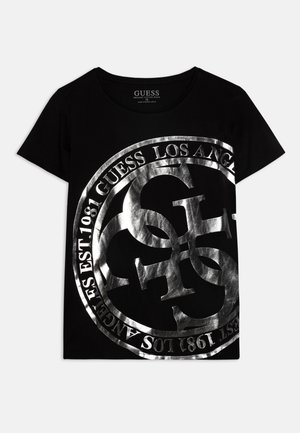 Schwarzes T-Shirt mit kurzen Ärmeln mit großem metallic-silbernem kreisförmigen Guess-Logo und Text "Guess Los Angeles Est. 1981" auf der Vorderseite.