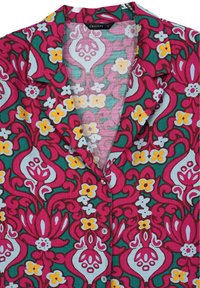 Camicia a maniche corte realizzata in tessuto leggero con un design floreale nei colori rosa, verde, giallo e bianco. Presenta un colletto a scialle e bottoni.