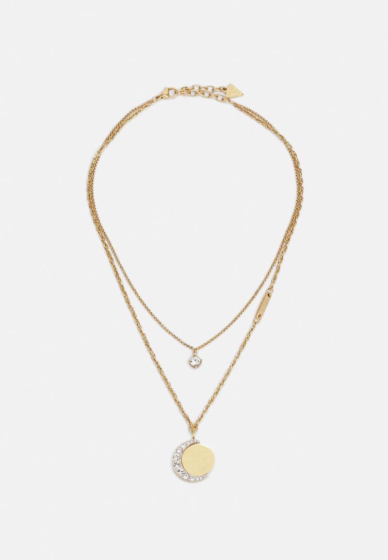 Collana a strati in oro con un ciondolo rotondo decorato con un design a mezzaluna arricchito da cristalli e un piccolo charm su una delicata catena.