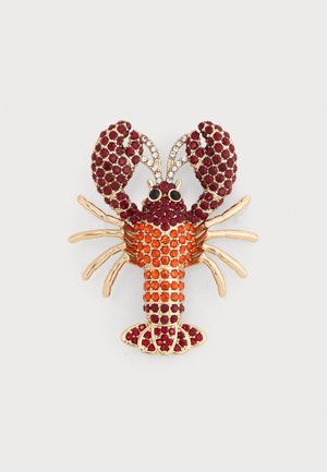 Broche en forme de homard en métal doré, ornée de pierres précieuses rouges et orange, yeux noirs et détails en strass clairs sur les antennes.