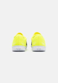 Scarpe da ginnastica giallo brillante con un design elegante, tomaia in mesh e suola in gomma bianca. Presentano un branding minimalista e accenti texturizzati sul tallone.