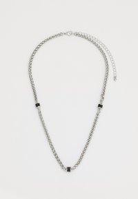 Collier en chaîne en métal argenté avec des maillons d'accent noir alternés et un fermoir à crochet. Présente une longueur ajustable avec une chaîne d'extension.