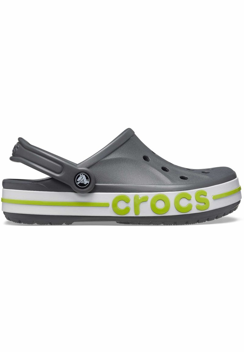 Crocs gris avec un design moulé, semelle blanche et logo "crocs" vert fluo. Dispose d'une sangle à l'arrière et de trous de ventilation sur le dessus.