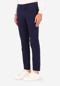 Pantaloni chino blu navy a vestibilità slim, realizzati in tessuto misto cotone. Presentano una chiusura con bottoni, tasche laterali e sottili dettagli di cucitura.