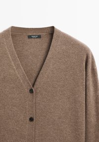 Cardigan di lana marrone con scollo a V, dotato di tre bottoni frontali e una trama morbida. L'etichetta interna riporta "Massimo Dutti."
