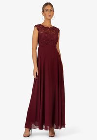 Bordeaux maxi jurk met een kanten lijfje en korte mouwen, met een vloeiende rok en transparante stof met een zachte textuur.