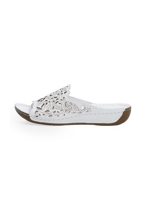 White slide sandal with cut-out floral design, smooth synthetic upper, brown rubber sole, rounded toe, and stitched detailing along the edges.