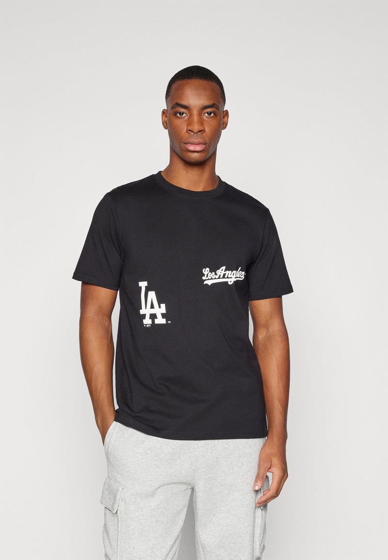 Camiseta negra de algodón con texto gráfico en blanco, que incluye "LA" y "Los Ángeles", cuello redondo y mangas cortas. Textura suave.