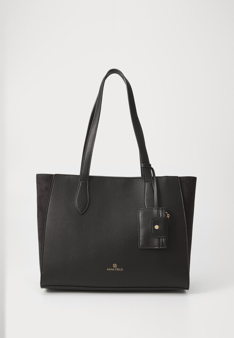 Black tote bag with textured leather and suede accents, rectangular shape, two handles, and a detachable small zippered pouch. Gold logo detail.