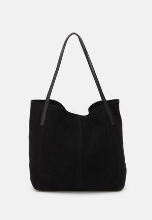 Borsa a tote in suede nera con due lunghe e piatte tracolle in pelle. Presenta un bordo superiore curvo e cuciture visibili sul davanti. Nessun elemento hardware.
