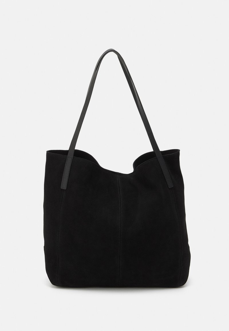 Sac fourre-tout en suède noir avec deux longues anses en cuir plates. Présente un bord supérieur incurvé et des coutures visibles sur le devant. Pas d'accents en métal.