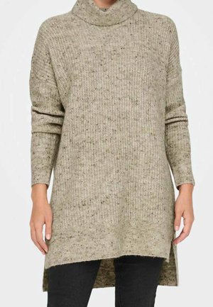 Sweater tunique en tricot beige clair avec des éclats plus foncés. Il dispose d'un col montant, de longues manches et d'échancrures sur les côtés pour une coupe décontractée.