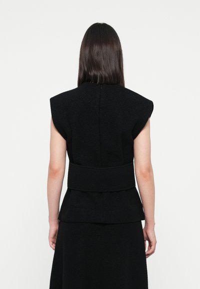 Black sleeveless top with structured shoulders, a fitted waist, and a peplum at the hem, made from a textured fabric.