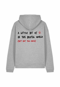 Pelēks kapuces džemperis ar kanguru kabatu. Aizmugurē ir melna un sarkana teksts: "MAZS ❤ ŠAJĀ BRUTĀLAJĀ PASAULĒ (BET NE PĀRĀK DAUDZ)."