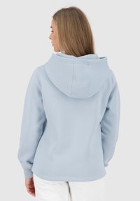 Felpa in pile azzurro chiaro con un grande cappuccio, polsini a costine e una texture morbida. Presenta un design semplice senza motivi o loghi visibili.