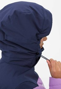 Marineblaue Kapuzenjacke mit hohem Kragen und verstellbarem Kordelzug. Sie hat einen rosa Akzent am unteren Ende und eine glatte, strukturierte Oberfläche.