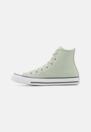 High-top sneaker in lichtgroen leer met witte rubberen zool en zwarte strepen, voorzien van metalen veteroogjes en vetersluiting.