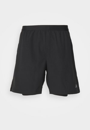 Calções atléticos pretos feitos de material leve com um cós elástico, apresentando rachas laterais e um pequeno logótipo na bainha inferior.