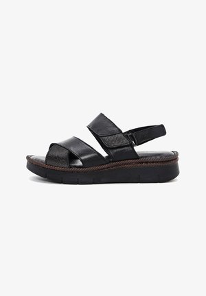 Schwarze Ledersandalen mit zwei breiten Riemen und einem verstellbaren Fersenriemen. Mit einer strukturierten Innensohle und einer niedrigen, gepolsterten Plattformsohle.