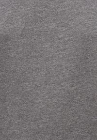 Γκρι ύφασμα με απαλή, λεία υφή και ελαφρύ μοτίβο χρωματισμού. Κατάλληλο για καθημερινή χρήση ή για στρώσεις, χωρίς εμφανή μεταλλικά εξαρτήματα ή διακοσμητικά στοιχεία.