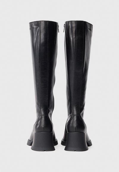 Botas negras de cuero hasta la rodilla con una textura lisa, con un tacón grueso y una cremallera lateral para cierre.