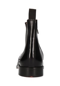 Schwarze Leder-Ankle-Boots mit glänzender Oberfläche, elastischen Seiteneinsätzen und einer Schlaufe an der Rückseite. Flache Sohle mit minimalem Profil.