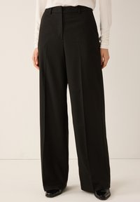 Black wide-leg trousers with a subtle pinstripe pattern. Features a flat front, belt loops, and a smooth fabric texture.