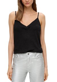 Haut sans manches noir avec un design en v, en tissu texturé, associé à un jean argenté brillant à coupe ajustée et poches frontales.