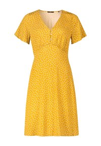 Robe jaune à manches courtes avec des pois blancs, col en V, trois boutons sur le devant et une jupe légèrement évasée.