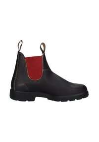Stivale alla caviglia in pelle marrone con pannello elastico laterale rosso, suola in gomma scura, linguette di presa e cuciture a contrasto lungo i bordi.