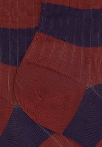 Calze a strisce rosse e blu navy con texture a coste, caratterizzate da bande orizzontali alternate e un'area del tallone e delle punte rinforzate.