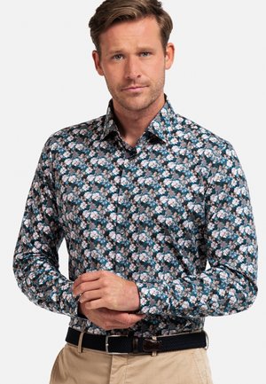 Chemise florale en coton, avec un fond bleu-vert foncé et des fleurs blanches et roses. Conception à boutons avec un col pointu.