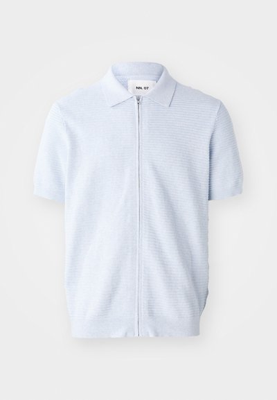 Svetlo modra polo majica s kratkimi rokavi, ima zadrgo in rebrasto teksturo, s klasičnim ovratnikom in ravnim robom.