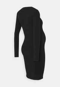 Robe noire à manches longues côtelée, silhouette moulante, col rond et design sans coutures, mettant en valeur une texture lisse et des lignes épurées.