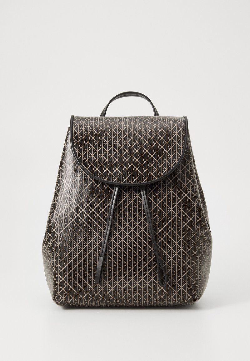 Sac à dos noir avec motif géométrique beige, fermeture à rabat et deux sangles en cuir suspendues sur fond blanc uni.