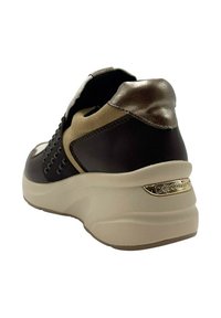 Zapatilla deportiva con parte superior de cuero marrón oscuro, acentos en topo, diseño perforado, detalle metálico en el talón y suela gruesa en beige.