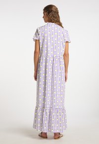 Rochie maxi cu mâneci scurte; material alb cu un model geometric în mov și galben; tiv ondulat; material ușor, fluid.