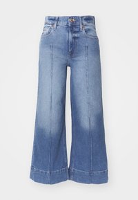 Jeans in denim a gamba larga in blu chiaro, caratterizzati da un alto punto vita, un design sbiadito, tasche frontali e dettagli cuciti lungo le gambe.