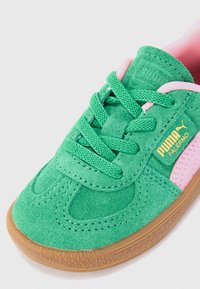 Grønne semskede Puma Palermo-sneakers med rosa detaljer, grønne snøringer og en såle av gummigummi.