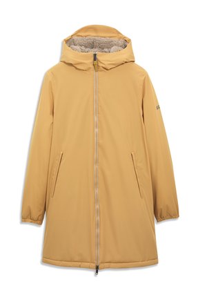 Homme portant une longue veste d'hiver à capuche jaune moutarde avec une fermeture éclair à l'avant et des poches latérales, debout devant un fond clair uni.
