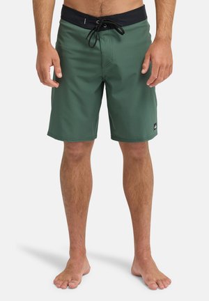 Zielone spodenki kąpielowe z czarnym troczkiem w pasie. Wykonane z gładkiego, lekkiego materiału. Posiadają małe logo po lewej stronie na dole.