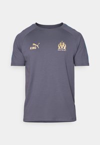 Marseille fodboldtrøje i mørkegrå stof. Udstyret med guld detaljer: "KING," Puma-logo og holdlogo. Korte ærmer, rund halsdesign.