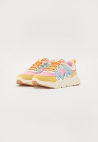 Baskets colorées avec un mesh rose, des accents en suède bleu, un capuchon de orteil jaune et des lacets orange sur une semelle blanche texturée.