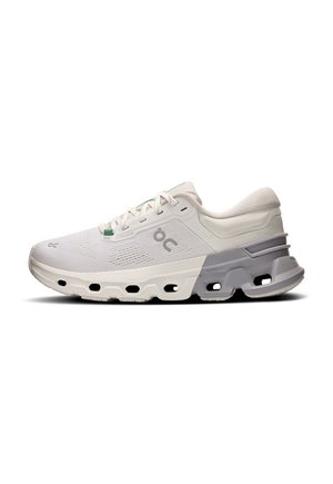 Baskets blanches de sport avec une tige en mesh, un système de laçage, et une semelle rembourrée distinctive avec des découpes et des accents gris.