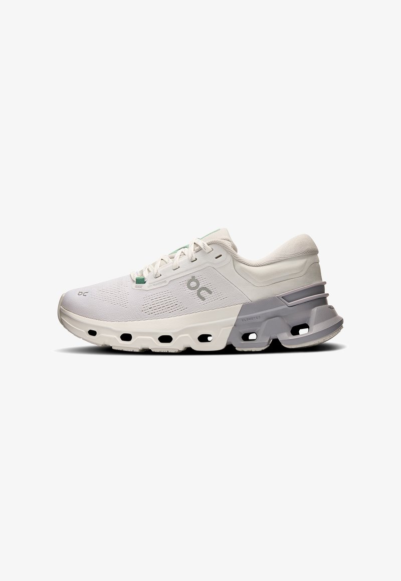 Baskets blanches de sport avec une tige en mesh, un système de laçage, et une semelle rembourrée distinctive avec des découpes et des accents gris.