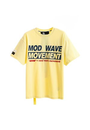 Camiseta amarilla de manga corta con texto en negrita azul marino y rojo "MOD WAVE MOVEMENT" impresa en la parte delantera y un pequeño diseño en la manga izquierda.