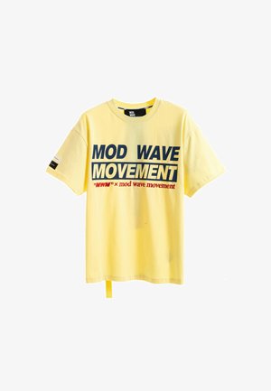 Camiseta amarilla de manga corta con texto en negrita azul marino y rojo "MOD WAVE MOVEMENT" impresa en la parte delantera y un pequeño diseño en la manga izquierda.