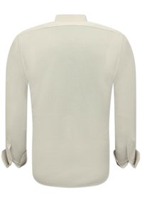 Lichtbeige lange mouw shirt met een rechte kraag en knoopmanchetten. Gladde textuur, met een eenvoudig, effen ontwerp zonder patronen.