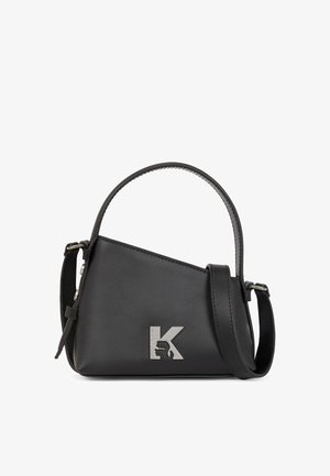 Černá kožená kabelka s trojúhelníkovým designem, horním uchem a nastavitelným ramenním popruhem, se stříbrným logem písmene "K" na přední straně.
