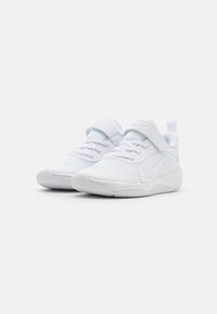 Scarpe da ginnastica bianche con pannelli in rete, lacci e una fascia in velcro. Punta rotonda, soletta imbottita e dettaglio del logo sul lato.